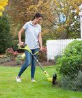 Woman using Pro Grade 18 Volt Cordless Grass Trimmer With Dual 2.0 Ah Batteries And Telescopic Handle on grass.