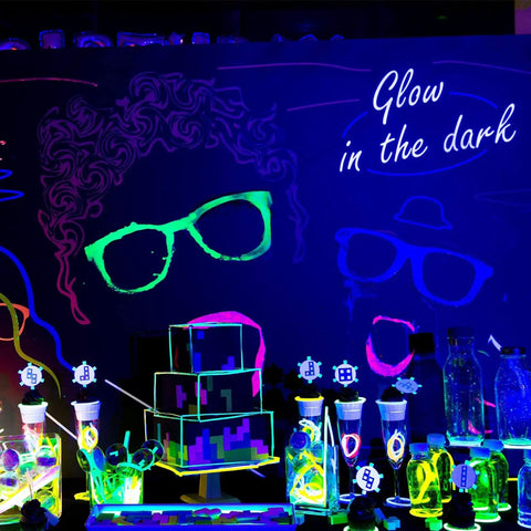 Black light setup with glow in the dark glasses, table decor, and Get Your Party Started With These 4 Pack LED Black Light Bars.