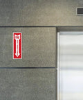 Fire Extinguisher Decal Self Adhesive Sticker 4x12 Inches 4 Mil Vinyl Sign For Indoor And Outdoor Use UV Protected And Waterproof Sleek Yet Tough As Nails Label Pack Of 3 installed on a gray wall near an elevator.