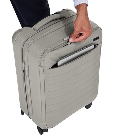 Person placing laptop in Softside Bigger Carry On Luggage 23 Inch Expandable With Spinner Wheels Built Tough Nylon Cloud Gray