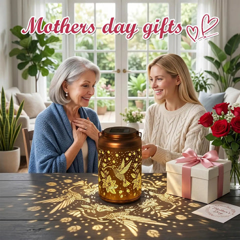 Hummingbird Solar Lanterns For Outdoor Garden Decor Waterproof Hanging Lights For Patio Porch Tree Yard Vintage Metal Lanterns With Gold Copper Finish Perfect Mothers Day Gift For Women Moms Grandmas Cozy Backyard Ornament displayed with roses and gift box.