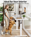 Sleek BIZUM Electric Standing Desk 60 x 24 Inch White with woman and dog, ideal for home office or gaming setup.