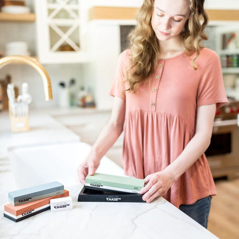 Woman using Pro Grade Knife Sharpening Kit With Whetstone Bowl, 15-Piece Set, Dual Grit stones in kitchen setting