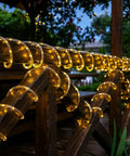66 Feet Of 200 LED Solar Rope Lights With 8 Modes No Fuss Waterproof Outdoor String Lights In Clear Tube For Garden Patio Deck Backyard Porch Pool Tree Decor Warm White Auto On Off on wooden railing at night