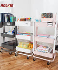 Organized rolling storage carts with books and supplies in white, black, and pink on a wooden floor