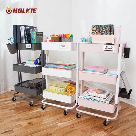 Organized rolling storage carts with books and supplies in white, black, and pink on a wooden floor