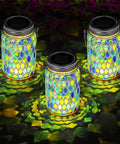 Three Piece Solar Powered Mosaic Lights Set For Outdoor Hanging Use Blue Lanterns Waterproof Night Lights For Tree Garden Patio Yard And Party Decor With Easy Hook Design displayed glowing on ground at night