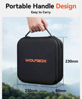 Hand holding a black hard case with orange WOLFBOX logo, dimensions shown as 230mm x 80mm x 230mm, against outdoor scene.
