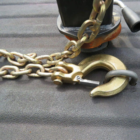 Close-up of 4 Pack 5/16 Inch Grade 70 Clevis Slip Hooks with Safety Latches and chain for towing tasks.