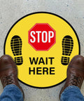 Five Pack Stop Here Floor Signs 18 Inch Round Vinyl Anti Slip High Visibility Stickers For Quick Queue Control And Social Distancing In Busy Places No Fuss, yellow STOP WAIT HERE floor decal on store floor