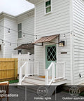 Porch Light With Built In Outlet GFCI No Fuss Outdoor Wall Sconce Lantern mounted on white house, patio setting