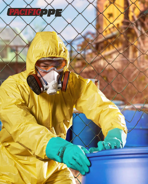 Person in yellow hazmat suit wearing Two Pairs Nitrile Chemical Resistant Gloves With Flocked Lining Latex Free Fifteen Mil Thick Twelve Point Six Inch Long X Large Ideal For Household Chores DIY Projects And Messy Cleanup With Tough Grip And Strong Chemical Guard handling blue barrels.