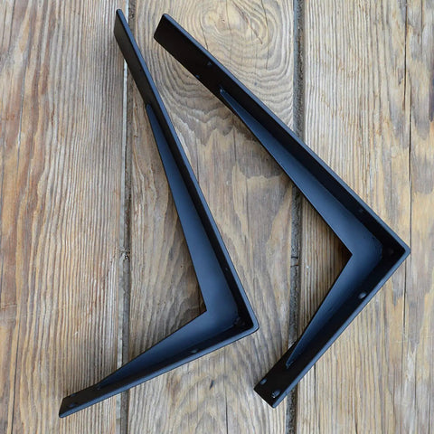 Heavy Duty Farmhouse Shelf Brackets Badass Rock Solid Iron Wall Mounts Black Metal Industrial L Braces viewed from above on wood.