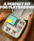Playground Active Travel Case For Game System Lightweight Durable Portable Storage held open by child's hands on table