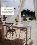 Outdoor dining scene with Teak Cleaner and Restorer for Outdoor Furniture on a table, chairs, and bright draped curtains.