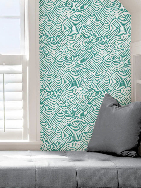 Saybrook Teal Peel And Stick Wallpaper With Aqua Wave Pattern for Renters and DIY lovers on wall next to gray cushion.