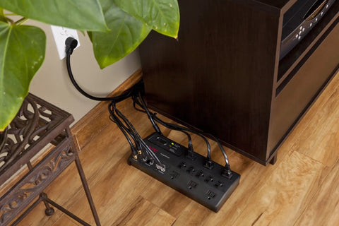 Beefed Up Heavy Duty Surge Protector Power Strip with 3020 Joules Eleven Outlets under a desk in a home office setting.