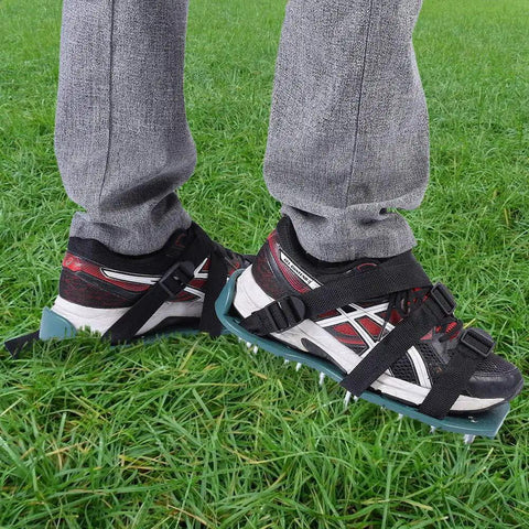 Person wearing spiked lawn aerator shoes with adjustable straps on green grass for easy walk aerate soil and boost absorption
