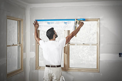 Person using Pro Grade Masking Film Kit With Static Cling 8 Rolls Of 48 In By 180 Ft Each Keeps Film In Place Flake Resistant Indoors