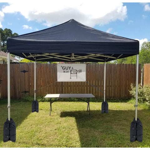 Beefed Up Heavy Duty Canopy Weight Bags Set Of 4 For Instant Outdoor Shelters up to 45 lbs each securing pop-up tent on grass.