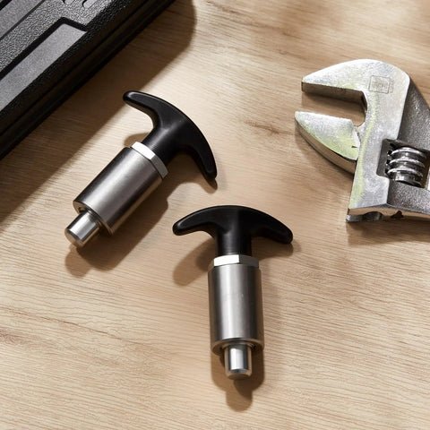 Two Pack Spring Loaded T Handle Pull Knobs With Badass Grip Built Tough As Nails For Welding Tables And Garage Shelves Locking Steel Shank Shock Proof Plastic Design Half Shank 3 15 Inches Long on wooden surface.