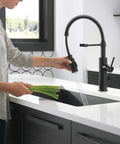 Heavy Duty Slick Finish Kitchen Faucet With Smooth Pull Down Spray Single Handle Matte Black Build in use rinsing veggies.