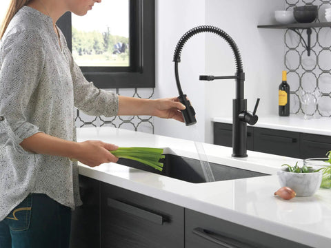Heavy Duty Slick Finish Kitchen Faucet With Smooth Pull Down Spray Single Handle Matte Black Build in use rinsing veggies.