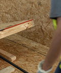 Guardian 2601 portable wall jack installed on a wooden post with a red cast-iron mounting clamp and black pipe