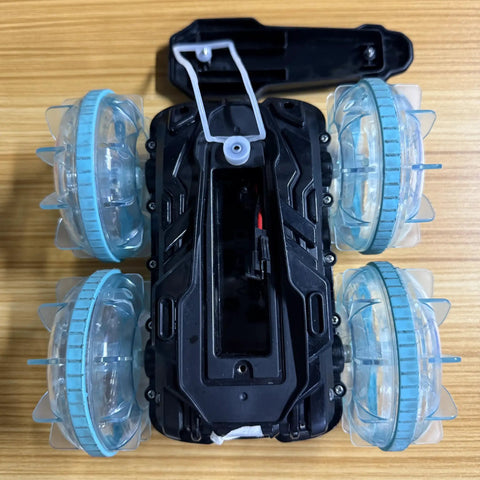 Top view of Amphibious 4WD RC Car And Boat Hybrid With Waterproof Design showing open battery compartment and clear wheel design.