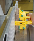 Hand using Kickback Buster 3D Push Block With Gravity Heel Kit For Table Saws on a wooden piece for precise cutting.