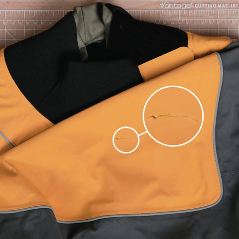 Orange and gray wader with close-up of tear, suitable for repair with Aquaseal FD Flexible Durable Repair Adhesive For Patch Up Tears In Waders Wetsuits PVC Inflatables Vinyl And Outdoor Gear Dries Clear In Any Weather 0.75 Oz 1 Pack.