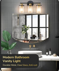 Chic Brushed Nickel 3 Light Vanity Light Over Mirror With Clear Glass Shades shown on dark tiled bathroom wall
