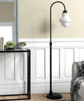 Tall Floor Lamp With Glass Shade In Blackened Bronze And White Milk Finish next to a console table in modern living room setting.