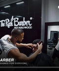 Barber using clippers on a client in The Rich Barber shop, featuring logos and modern interior design.