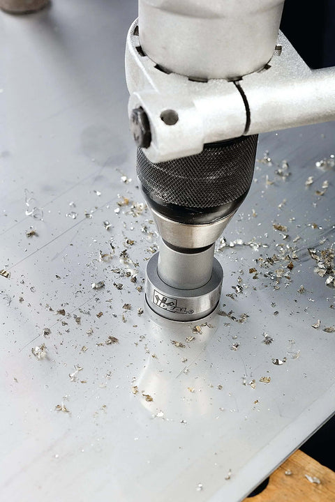 IDEAL carbide hole cutter on metal surface with shavings; silver tool with knurled black grip