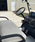 High Capacity Six Passenger Electric Golf Cart Featuring Rear Flip Seats Quiet Motor Drive plush padded upholstery and built in armrests, driver's seat with dashboard.