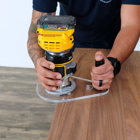 Close-up of a person using a 6X9 Router Base Plate In Clear Acrylic Sets A Dead On Fit For Dewalt Dwp611 And Dcw600b on wood.