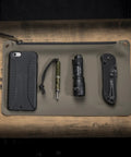 Dual Output LED Backup Flashlight With MaxVision Beam Technology surrounded by everyday carry items on a mat