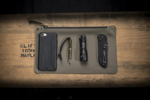 Dual Output LED Backup Flashlight With MaxVision Beam Technology surrounded by everyday carry items on a mat