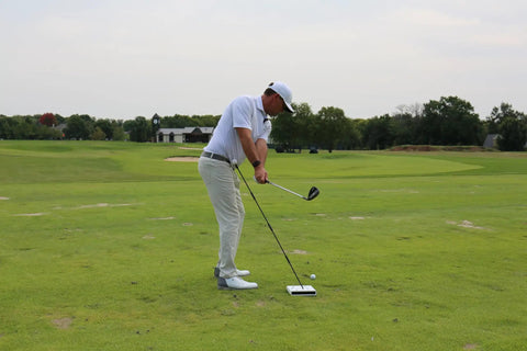 Golfer using Golf Swing Trainer Cube With 12 Adjustable Club Positions, Guided Strikes Tool at the range to improve accuracy