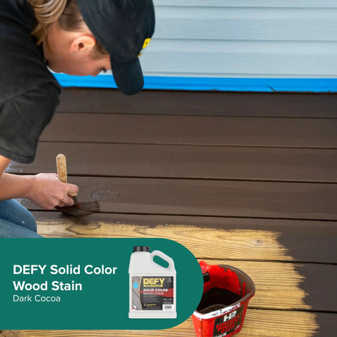 Person applying Dark Cocoa stain on wooden deck using Solid Color Wood Stain For Decks And Fences UV Resistant Opaque Finish