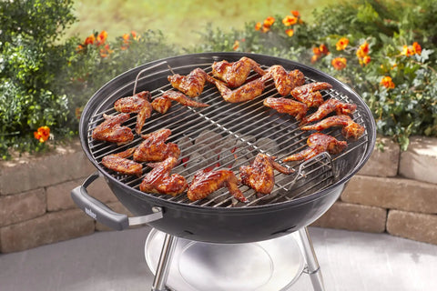 Premium 22 Inch Charcoal Grill Portable Outdoor BBQ Grill With Durable Plated Steel Grates Porcelain Enamel Bowl And Precision Airflow Control For Bold Flavor On The Go Tailgate Ready with chicken wings grilling outdoors.