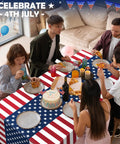 People dining on Patriotic Fourth Of July Tablecloth Set Two Pack 54 By 108 Inches Plastic Outdoor Party Cover with American flag design.