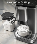 Top Shelf Fully Automatic Espresso Machine With Built In Grinder, 20 Bar Pressure, Smart Touch Display, Quick One Touch Brewing For Smooth Sips, Integrated Milk Frother, 15 Grind Settings, No Brainer Home Setup, Silver frothing milk into a glass cup on a countertop.