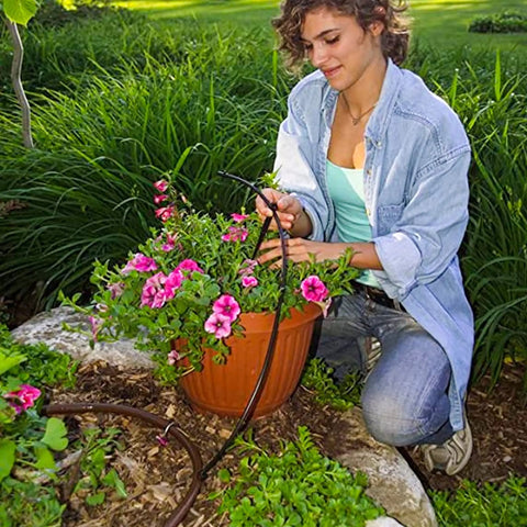 Person installing 50 Foot Flexible PVC Distribution Tubing For Irrigation Drip System One Quarter Inch Drip Line Durable Garden Hose