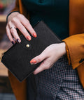 Person holding RFID Blocking Wallet For Women Large Capacity Bifold Card Holder with Zipper Pocket in black leather