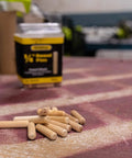 1/4-Inch Fluted Wood Dowel Pins on workbench, 72 Count Pack, visible chamfered ends for easy insertion, FSC-certified hardwood.