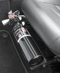 Compact Halon 1211 Auto Fire Extinguisher in black, positioned under a car seat for easy access, designed for daily drivers.