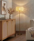 Rowan Brass Floor Lamp With Unique Thread Shade beside a sofa, creating a boho to mid-century decor vibe in a living room.
