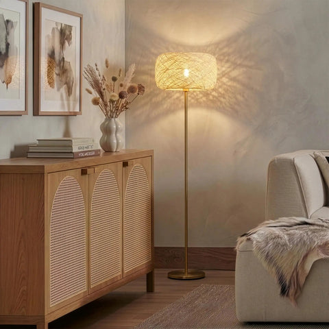Rowan Brass Floor Lamp With Unique Thread Shade beside a sofa, creating a boho to mid-century decor vibe in a living room.